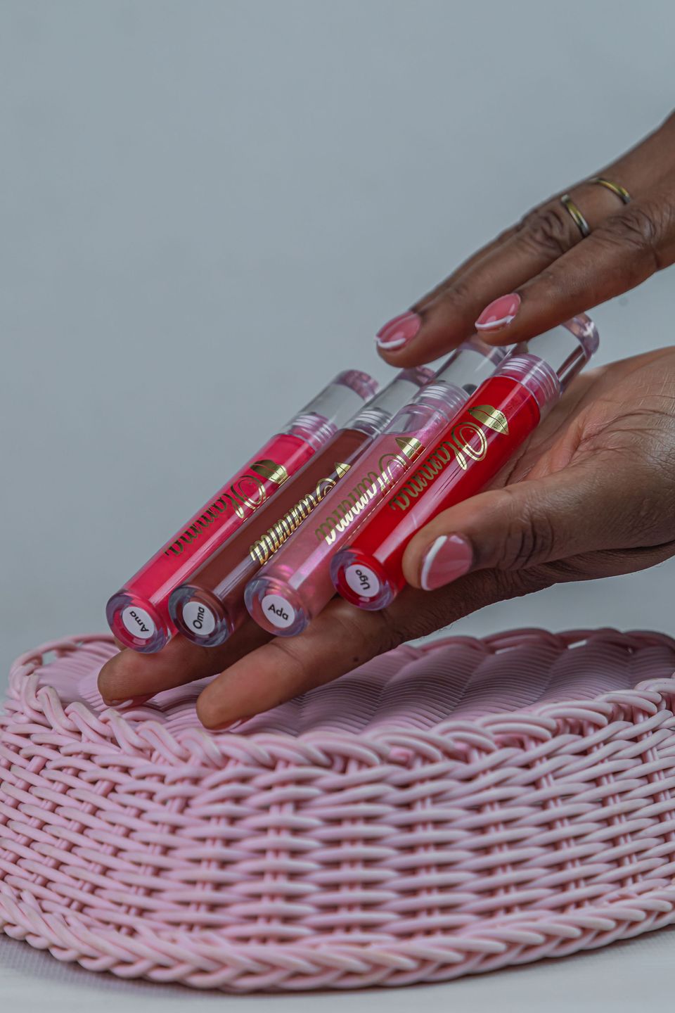 All four OLAMMA gloss tubes on a pink basket